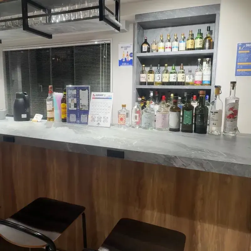 Workspace & Bar 56 のバーカウンターと棚に並ぶボトル類